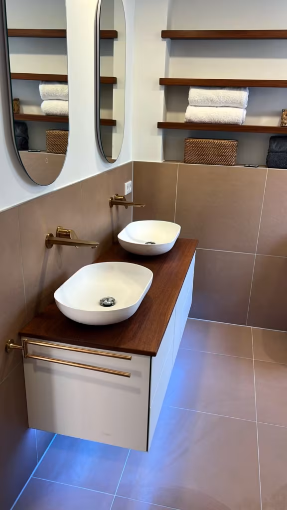Zwei Aufsatzwaschbecken mit Wandarmaturen in Messing auf Holzwaschtisch